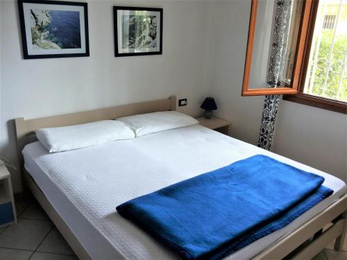 比比翁Azzurro的一间卧室配有一张带蓝色毯子的床