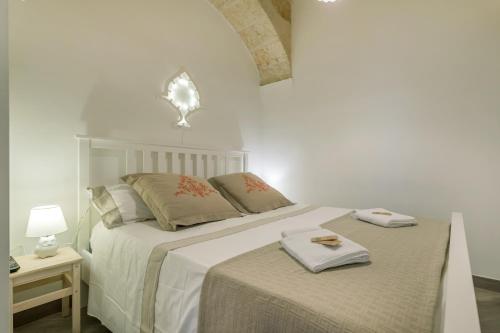 滨海波利尼亚诺CIVETTHOUSE : la casa delle civette的白色卧室配有两张带毛巾的床