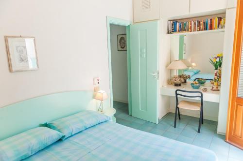 马里迪莫Acquamarina guest house的一间卧室配有一张床和一张桌子及椅子