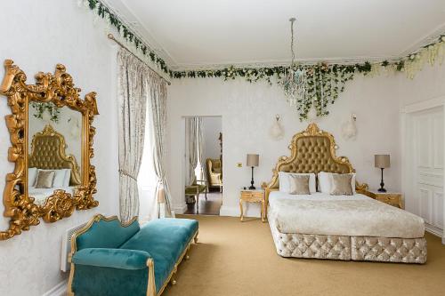 RainhullRainHill Hall Hotel的一间卧室配有一张床、镜子和一张沙发
