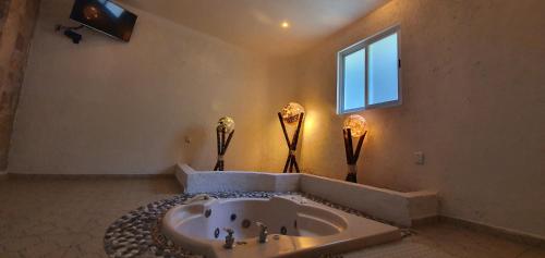 伊斯塔潘德拉萨尔Victoria Hotel y Spa的一间带大浴缸和窗户的浴室