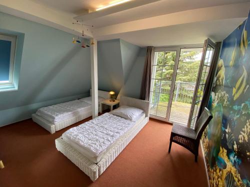 维滕贝克Ferienwohnung im Poolhaus mit Ostseeblick的一间卧室设有两张床、一把椅子和一个窗户。