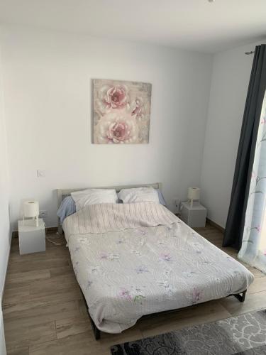 马里尼亚讷Appartement à Marignane的卧室配有一张床,墙上挂有绘画作品