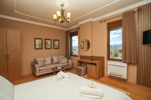 戈里察Vila 3 Korçë的一间卧室配有一张床、一张沙发和一台电视