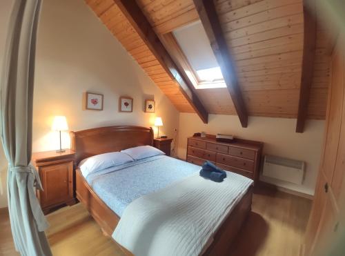 比利亚努阿Duplex Familiar Izarraitz的一间卧室设有一张大床和木制天花板