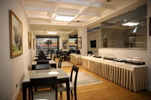 伏罗拉Hotel IMPERIAL的一间在房间内配有桌椅的餐厅
