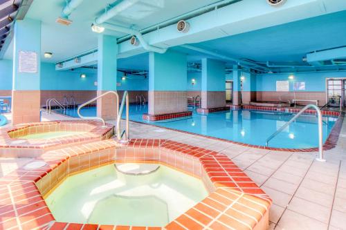 奥兰治比奇The Phoenix V Resort的一座大楼内带热水浴池的游泳池