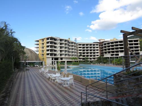 圣阿马鲁-达因佩拉特里斯Belíssimo resort com casa com banheiras água termal的一座带白色桌椅的游泳池