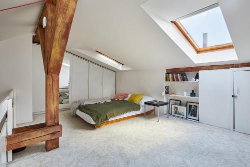 布拉格Sunlit Attic Loft in Vinohrady by Prague Days的一间卧室配有一张床和天窗