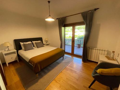 吉尔斯Casa do Pedrógo的一间卧室设有一张床和一个滑动玻璃门