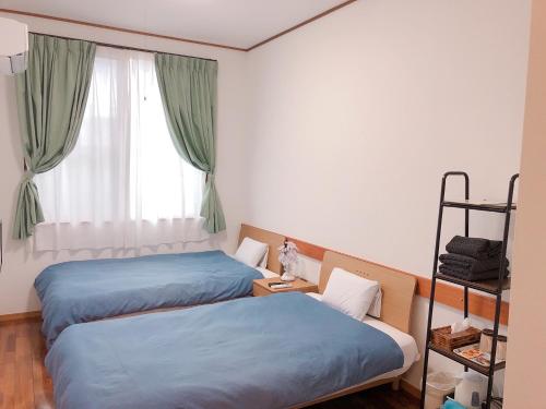 石垣岛霍亚酒店的带窗户的客房内的两张床