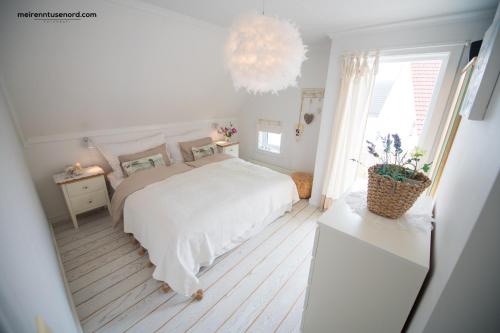 Kalvåg卡瓦贾假日公寓的白色卧室配有一张床和一个吊灯