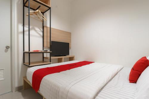 雅加达RedDoorz near Seasons City Mall 3的卧室配有一张带红色毯子的白色床
