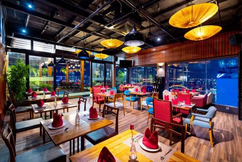 岘港辉煌酒店的餐厅设有桌椅,并备有帽子