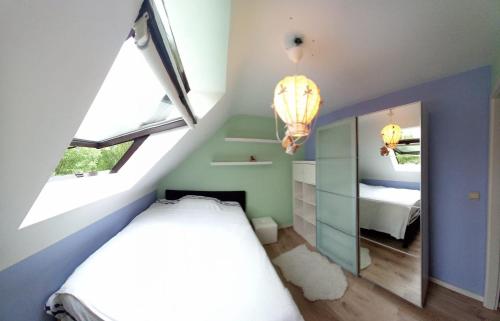 瓦夫尔Les prussiens的小型阁楼卧室配有1张床和1面镜子