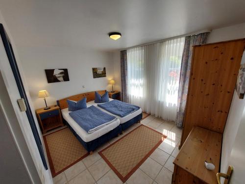 萨斯尼茨Apartment Feodora的一间卧室配有一张带蓝色床单的床和一扇窗户。