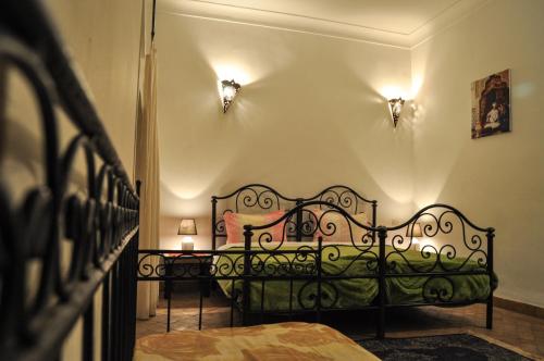 马拉喀什Riad Mandalay的一间卧室配有一张黑色的床和两张桌子