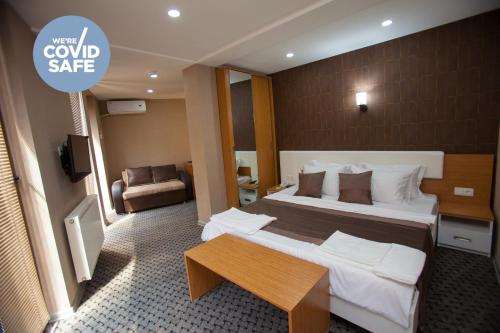 第比利斯旅行者酒店的酒店客房设有一张大床和一张桌子。