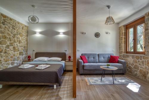 乌尔齐尼Stonehouse in Olives的一间卧室配有一张床和一张沙发