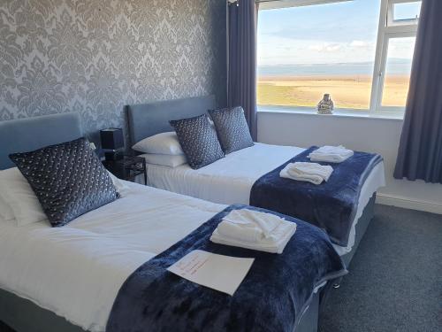 莫克姆Balmoral的酒店客房设有两张床和窗户。