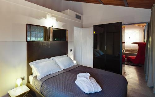 RodigoIl Tesoro Living Resort的一间卧室配有一张带白色毛巾的床