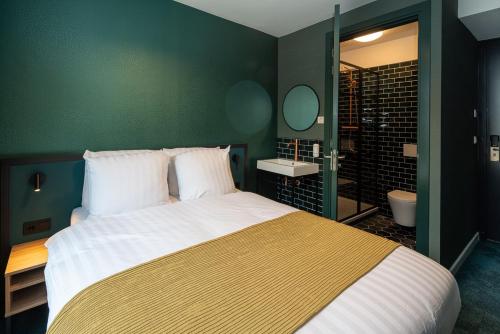 鹿特丹FD Hotels的一间卧室设有一张大床和绿色的墙壁