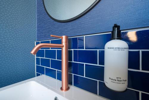 鹿特丹FD Hotels的浴室水槽,在镜子旁装有一瓶水