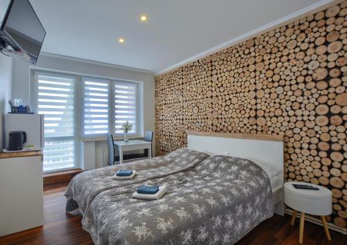 克雷尼察Willa Białe Tarasy的一间卧室设有一张大床和一堵木墙