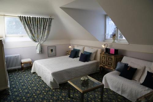 巴登韦勒Villa Hedwig的酒店客房,设有两张床和一张沙发