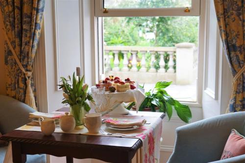 巴尔布里根Bedford House & Hall的一张桌子,上面放着一碗水果,放在窗边