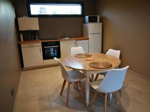 MarchésieuxTerre des marais的厨房配有木桌和白色椅子