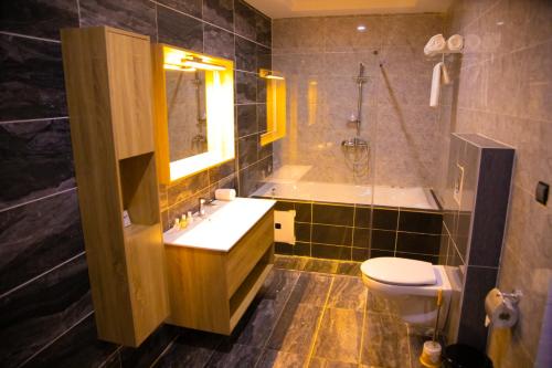 科托努Hotel La Casa Cielo的一间带水槽、浴缸和卫生间的浴室