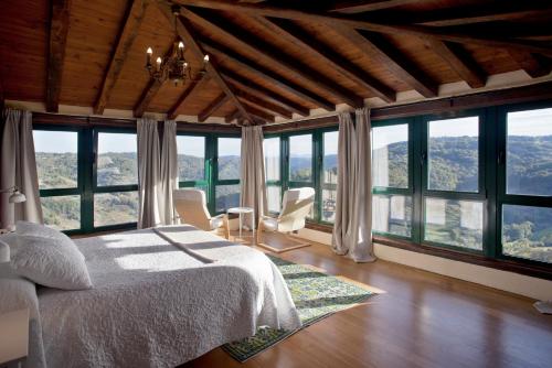 钱塔达Casa Vistaboa Ribeira Sacra的一间卧室设有一张床和大窗户