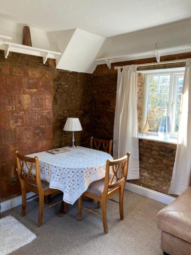 Holcot Cottage的一间带桌椅和窗户的用餐室