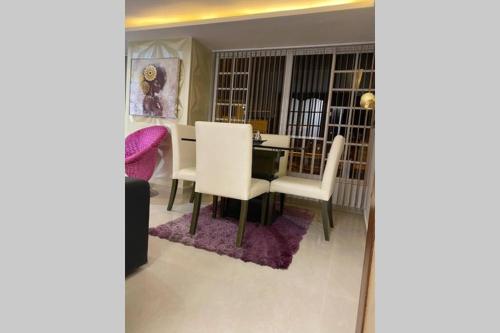 马尼萨莱斯Espectacular apto amoblado, bien ubicado 3 piso的一间带桌子和白色椅子的用餐室