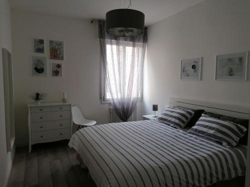 科内利亚诺ANGELA GUEST HOUSE in centro storico的一间卧室配有一张床、一个梳妆台和一扇窗户。