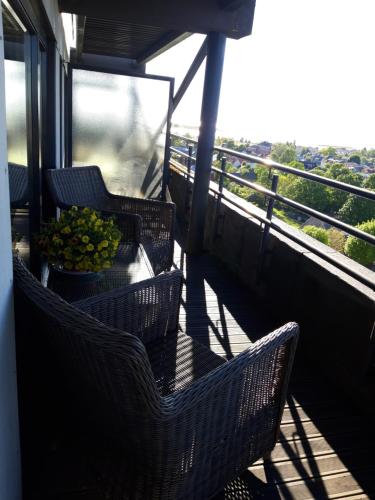哈普萨卢Panorama Apartment的阳台配有藤椅和一碗水果