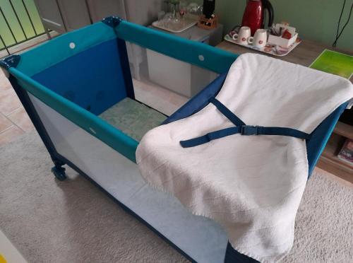 阿特La chambre Tomis Ath的一间房间里带白色毯子的蓝色婴儿床