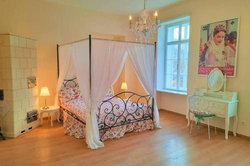 赖兴瑙Sisi-Schloss Rudolfsvilla - Trio - 12 Gäste的一间卧室设有一张天蓬床、一张桌子和一个窗户。