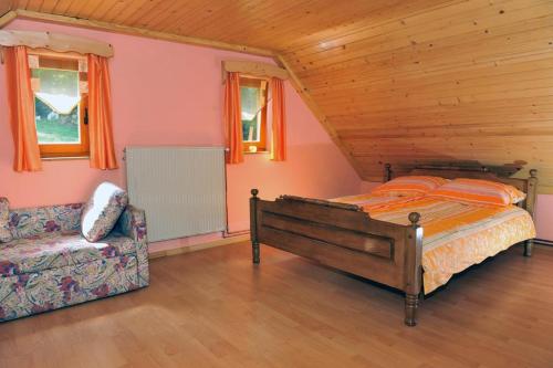 RogatecTuristična kmetija Kunstek的一间卧室配有一张床、一张沙发和窗户。