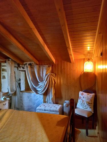 洛萨Talasnal Casas da Urze TER的一间卧室,卧室内配有一张床和一把椅子