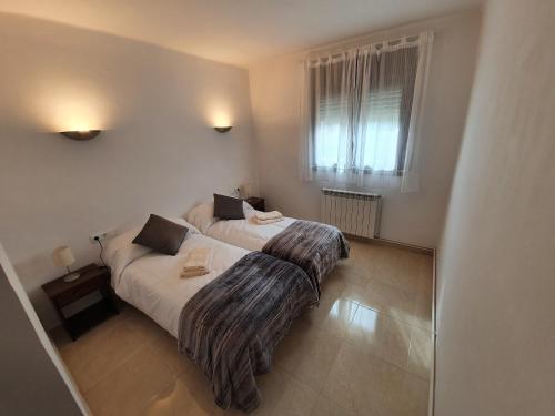 里贝斯的弗里瑟Apartament Vall de Ribes的一间卧室设有一张床和一个窗口