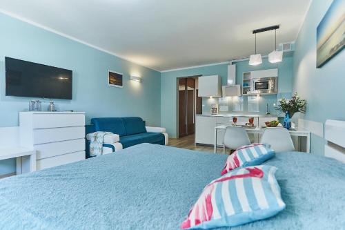 斯维诺乌伊希切Apartament Słoneczny的一间蓝色卧室,配有一张床和一间厨房