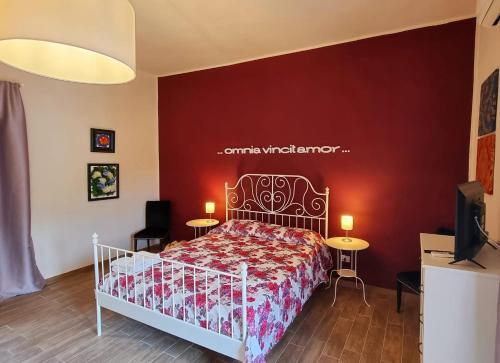卡塞塔Ercole' s Home的一间卧室配有一张红色墙壁的床