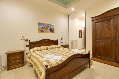 尼科泰拉B&B il Baglio的一间卧室配有一张大床和一个木制橱柜