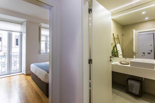 里斯本Prestige Ajuda Apartment的一间卧室配有一张床,浴室设有水槽