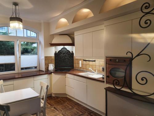 格但斯克Serce Gdańska的厨房配有白色橱柜、水槽和微波炉