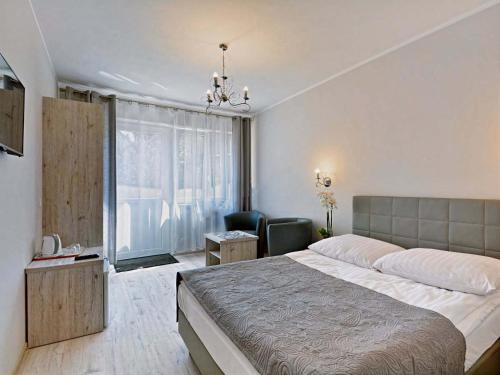 米泽德沃兹Arka - pokoje z osobnymi wejściami na parterze的卧室配有床、椅子和窗户。