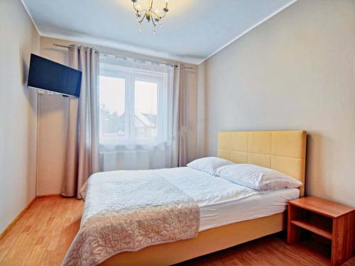 米泽德沃兹Pokoje Arka的一间卧室设有一张大床和一个窗户。