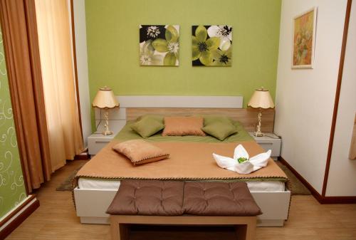 埃里温阿佐盐旅馆的一间卧室配有一张带两张桌子和鲜花的床
